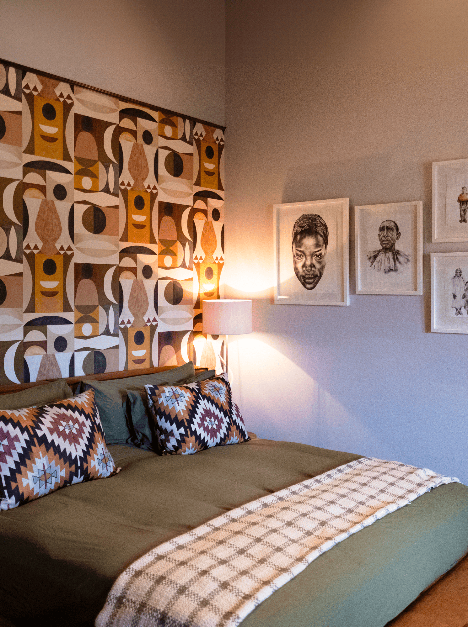 Stay with a Cozy bedroom with a patterned headboard, framed art, and a bed with decorative pillows.