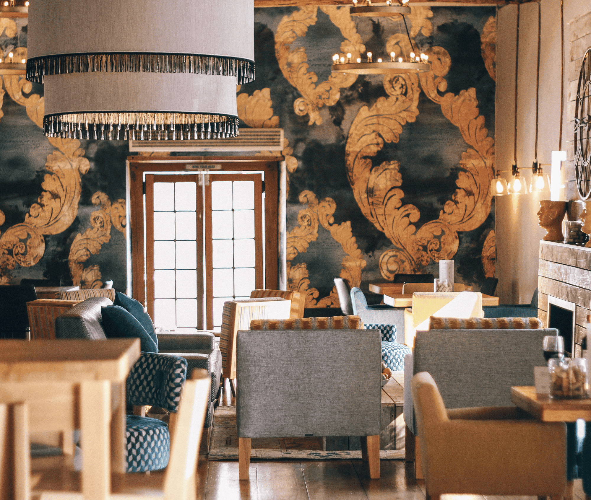 Elegant restaurant interior with ornate wallpaper and comfortable seating.