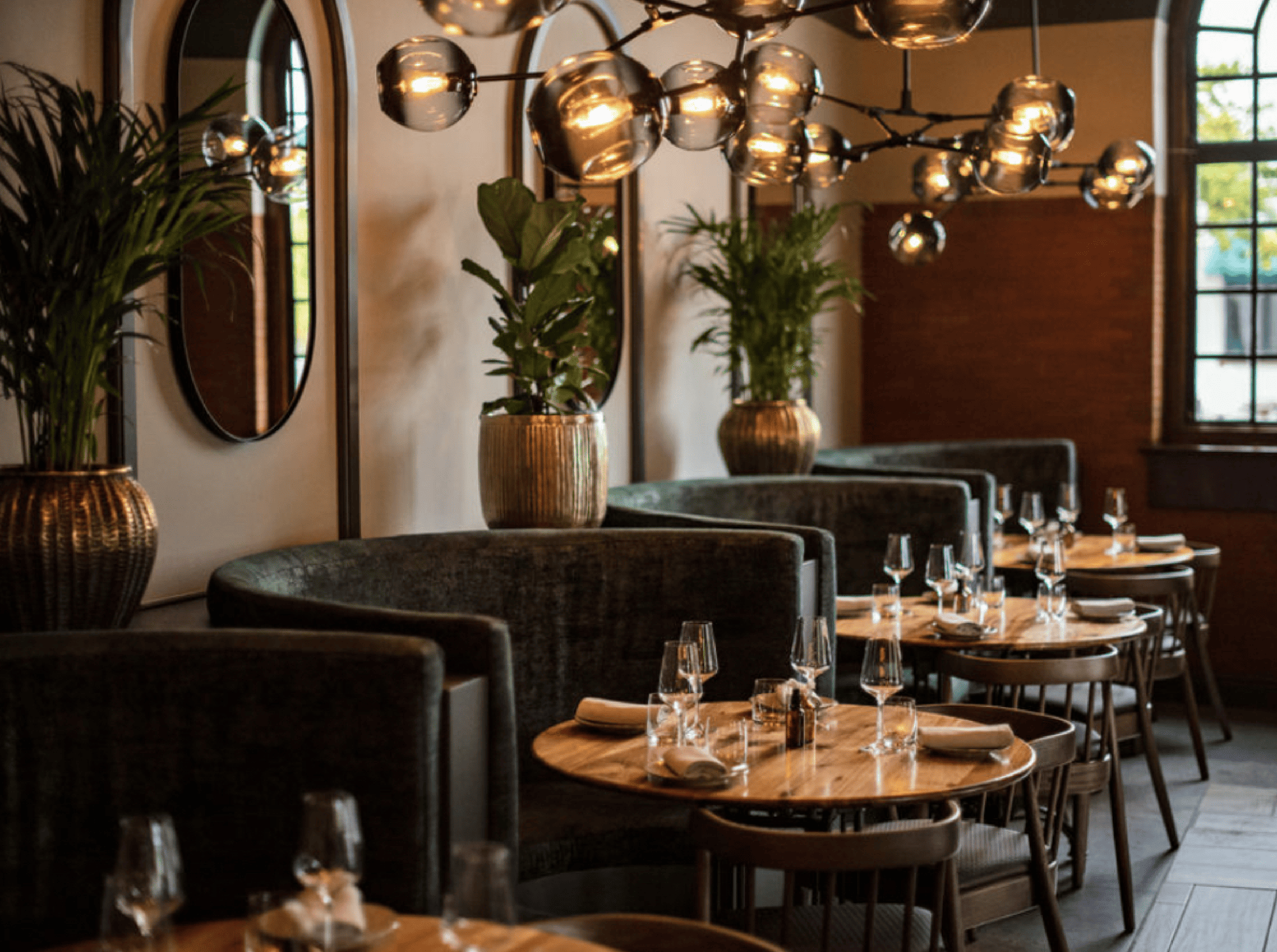 Elegant restaurant dining room with plush seating, round tables, and ambient lighting, seen as you explore the Cape Winelands